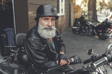 Fototapeta na wymiar Serious glancing mature man using motorcycle