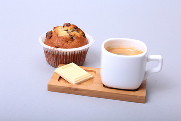 Classic espresso in white cup with homemade cake and chocolate on white background.