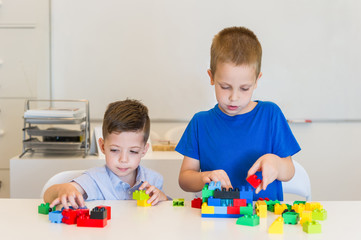 Obraz premium two child boy playing with cubes on the table