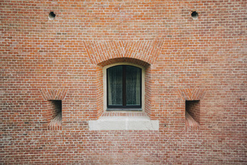 Fototapeta na wymiar White painted wood arched window in a red brick wall .
