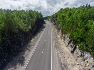 Fototapeta na wymiar Country two lane highway is between rocks, aerial view