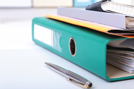 Folder file, note and pen on the desk. blurred background.