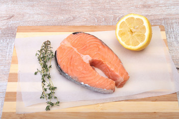 fresh raw salmon with spices and lemon on wooden cutting board. ready for cookin