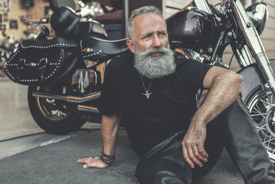 Dreamy old man locating near motorcycle