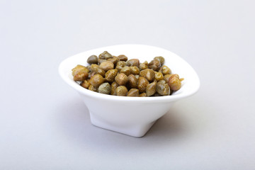 bowl with fresh capers isolated on white background.