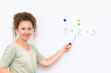 teacher woman teaches how to count on whiteboard in the classroom