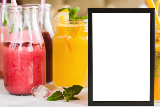 Blank picture frame with fresh fruit drinks behind. Food blogs, menu and recipes for web sites of cafe and restaurant, close up picture with copy space