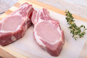 Raw pork chops, spices and rosemary on cutting board. Ready for cooking.