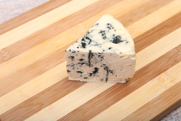 Plate with Tasty blue cheese on wooden table