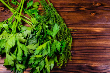 Bunch of parsley and dill on wooden table. Top view