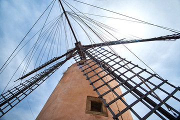 Fototapeta premium Beautiful old spain windmill against colorful sky with clouds. Spring landscape in the morning in Paguera. Rural scene. Travel background.