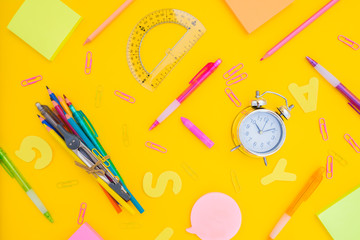 back to school or office styed pattern scene with multicolored school supplies on yellow