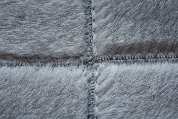 Short gray fur sewn with seams, detail of warm winter clothing