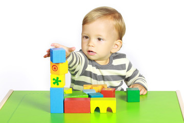 Ein einjähriger Junge spielt mit Holzspielzeug 