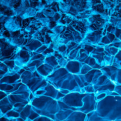 Fototapeta na wymiar Water in swimming pool with sun reflection. Blue water. Water abstract background