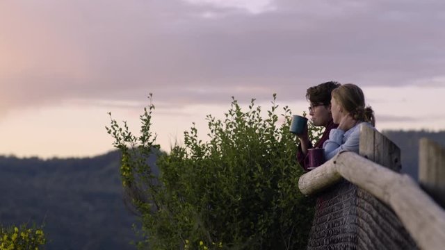 Camping Couple Flirt And Watch Sunset, Enjoy Drinking Hot Cocoa After Long Hike