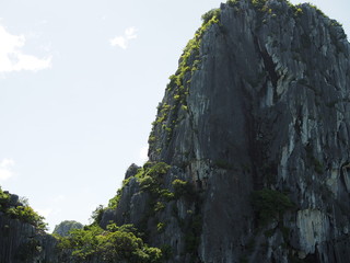 High cliff edge in Ha long bay, Vietnam, with cloudy white sky