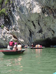 Tourist bamboo boats heading to the cave beneath the cliff in Ha long bay, Vietnam