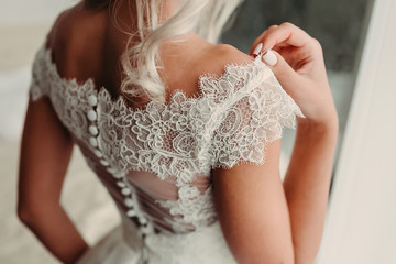 Close-up image of bride's shoulder in luxury laced dress. Wedding details