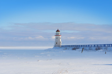 Lighthouse in a calm and desolate winter landscape.
