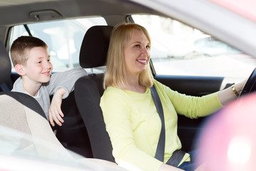 Adult mom and son driving in city during tour