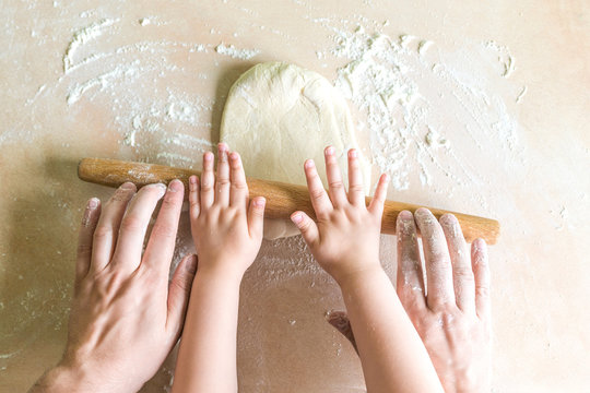 Children and dad hands rolled dough