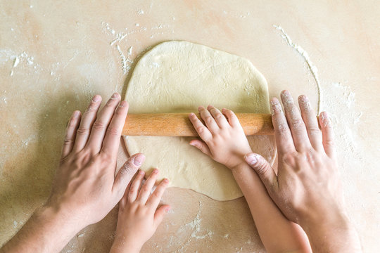 Children and dad hands rolled dough