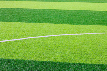 Fototapeta premium Photo of a green synthetic grass sports field with white line shot from above