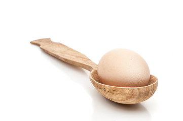 Fototapeta na wymiar chicken egg in a wooden spoon isolated white background