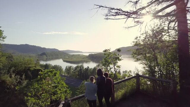 Group Of Friends Enjoy View Of Columbia River Gorge From Scenic Overlook, Drone Flies Over Them (Toward River)