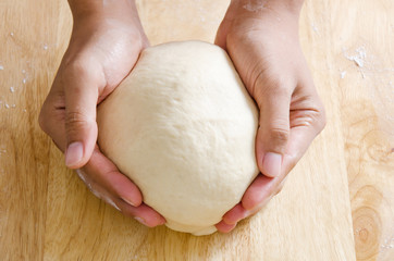 Bread cooking,kneading bread dough by hand on wooden board. Homemade bakery at home