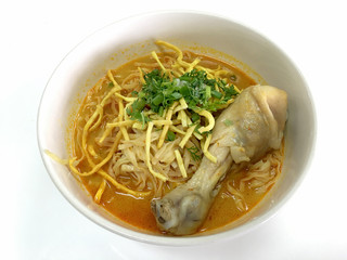 Thai spicy food, Egg noodle in chicken curry in white blow on white background or name in thai is khao soi kai, local cuisine North of Thailand.