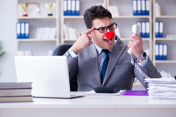 Clown businessman angry frustrated working in the office