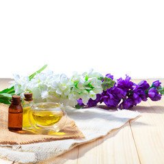 bottle of aroma essential oil or spa and natural fragrance oil with flower on wooden table isolated white background with clipping path