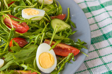 Fresh green salad with arugula, tomatoes, eggs and cucumber
