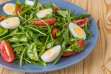 Fresh green salad with arugula, tomatoes, eggs and cucumber