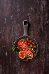 Sliced fresh red tomatoes with spices and herbs