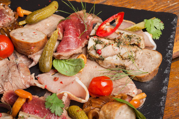Assorted meat appetizers with vegetables.