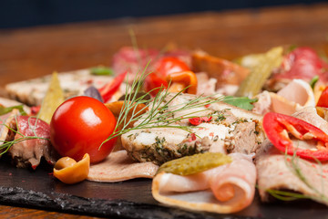 Assorted meat appetizers with vegetables. Close up.