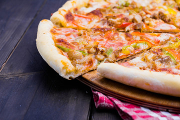 Delicious classic Mexican pizza with bacon, mushrooms, peppers, onion, tomatoes, Jalapenos and cheese isolated on white background