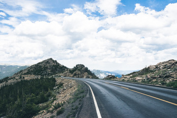 Fototapeta premium Road through the mountain pass in the Rocky Mountains. Traveling on summer holidays