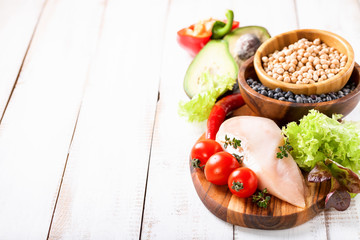 Raw chicken and fresh vegetables on a table. Healthy food. Selective focus. Copy space