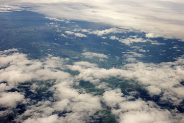 Fototapeta na wymiar aerial photo from window of plane, above ground and cloud, green field under the clouds