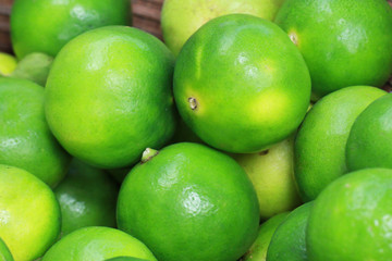 group of Fresh organic green lime Citrus lemon in wooden tray, at fresh market on asian fruit section