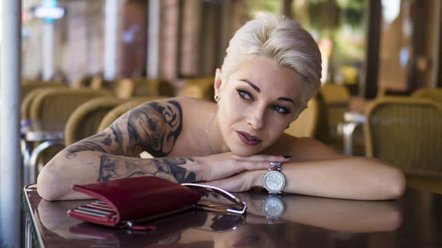 Tattoed woman in cafe.