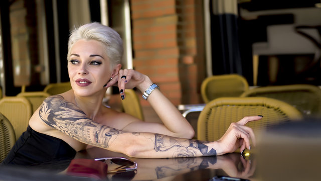 Tattoed woman in cafe