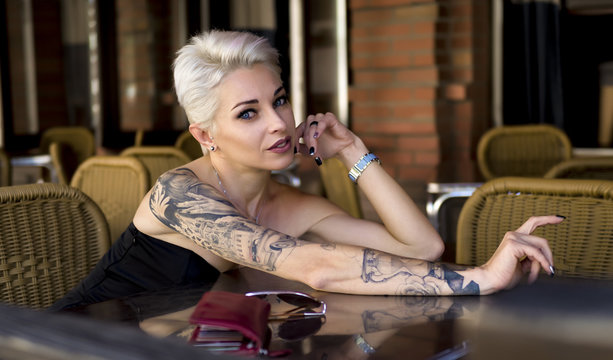 Tattoed woman in cafe