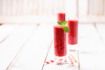 Strawberry smoothies in a glass on a light wooden background. Selective focus. Copy space