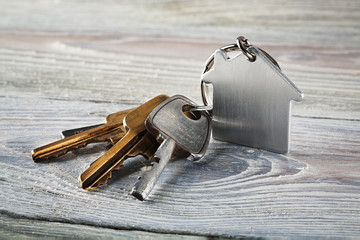 estate concept, keychain with house symbol, key on wooden background