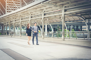 Obraz premium Business people walking through passage office. Smiling to each other.